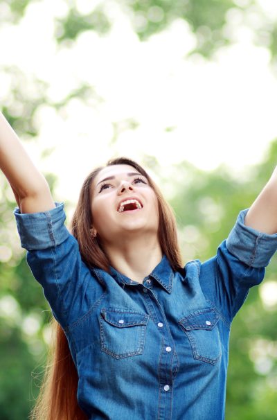 happy woman under a tree in summer